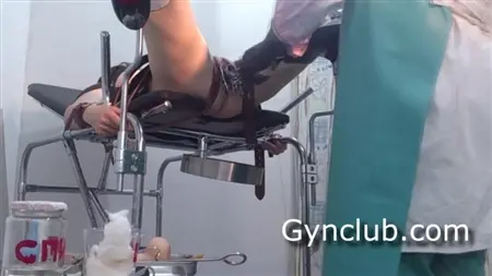 Una paziente legata in un ginecologo geme quando un medico diteggia la figa